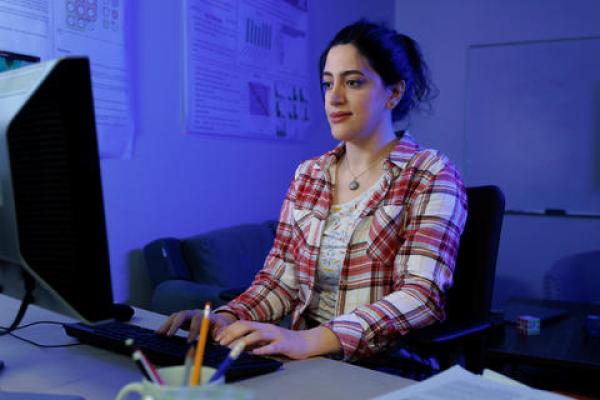 Girl working on a computer in a room.