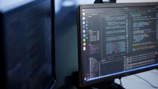 desktop computer with software code on screen