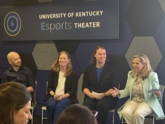 Four individuals sitting on stage for a panel discussion around AI